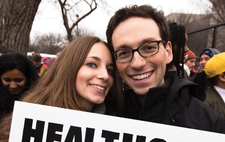 Photo of Kira Ganga Kieffer ’08 and Aaron Eisman ’08, at a rally with a sign that says "Healthcare is a Human Right."