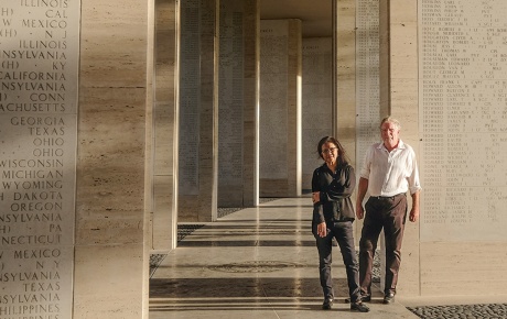 Mark Gillen ’77 and his wife, Delmafe Festin, standing at the Manila American Cemetery between stone columns