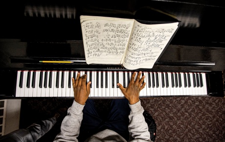 Image from above of Derrick Pennix playing the piano