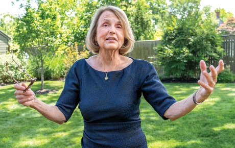 Image of Tracy Breton mid-explanation with green grass and trees in the background. 