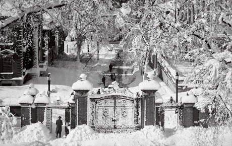Image of the Van Wickle gates covered in snow in the early 20th century looking down College Hill