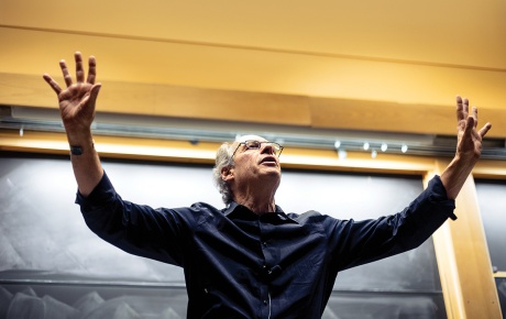 Image of Jim Marone teaching City Politics with his arms up and a chalkboard at his back in a classroom at Brown.