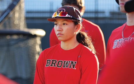 Image of Olivia Pichardo in Brown baseball uniform standing with her teammates.