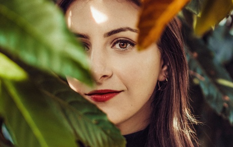 Image of Dana Schwartz looking through leaves