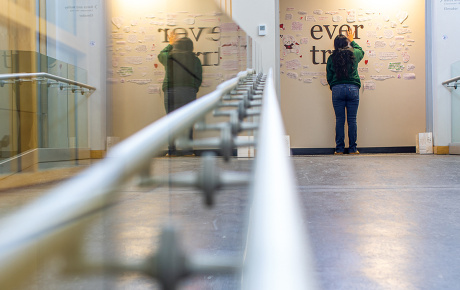 a student stands at a memorial wall