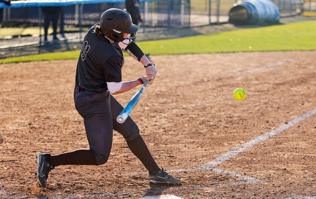A softball player hitting the ball
